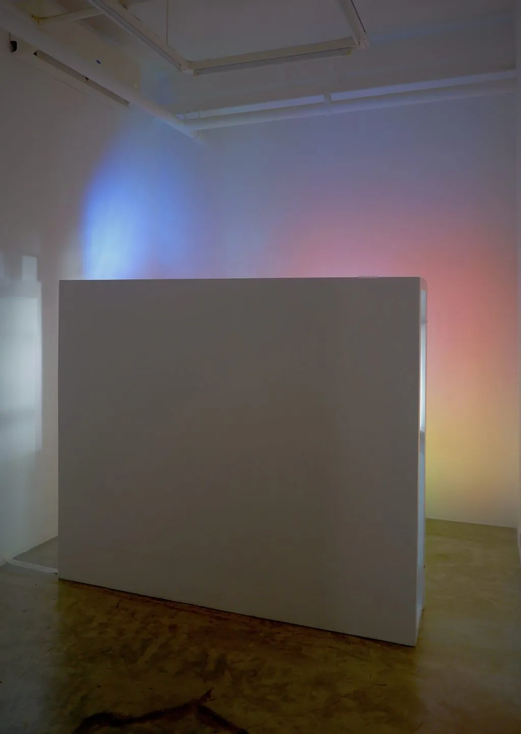 The back of the wall, with pink and blue light cast on the gallery walls