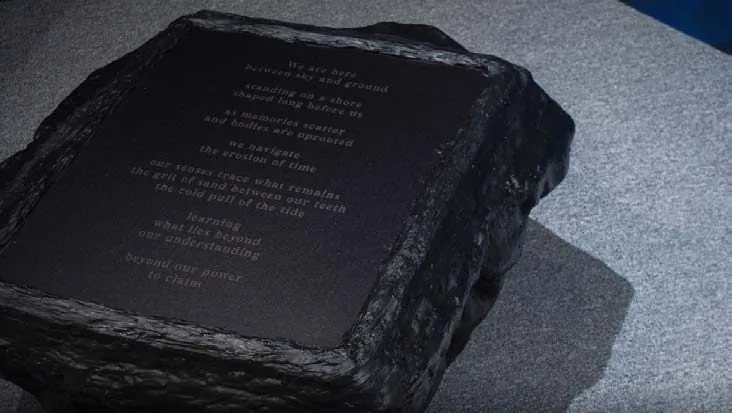 Close-up of a black resin form with engraved text on its top surface