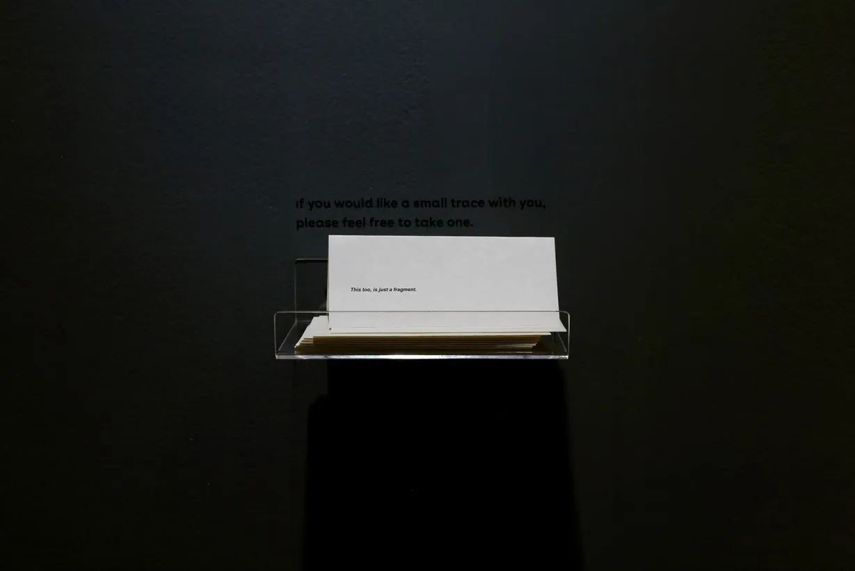 Iterations: a small stand holding translucent sheets of a poem for visitors to take