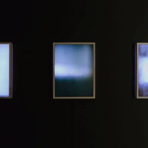 Light Residual II: a blurred blue backlit print between two others