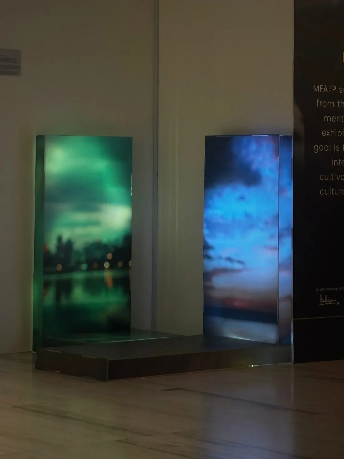 The two panels glowing green and blue in the gallery