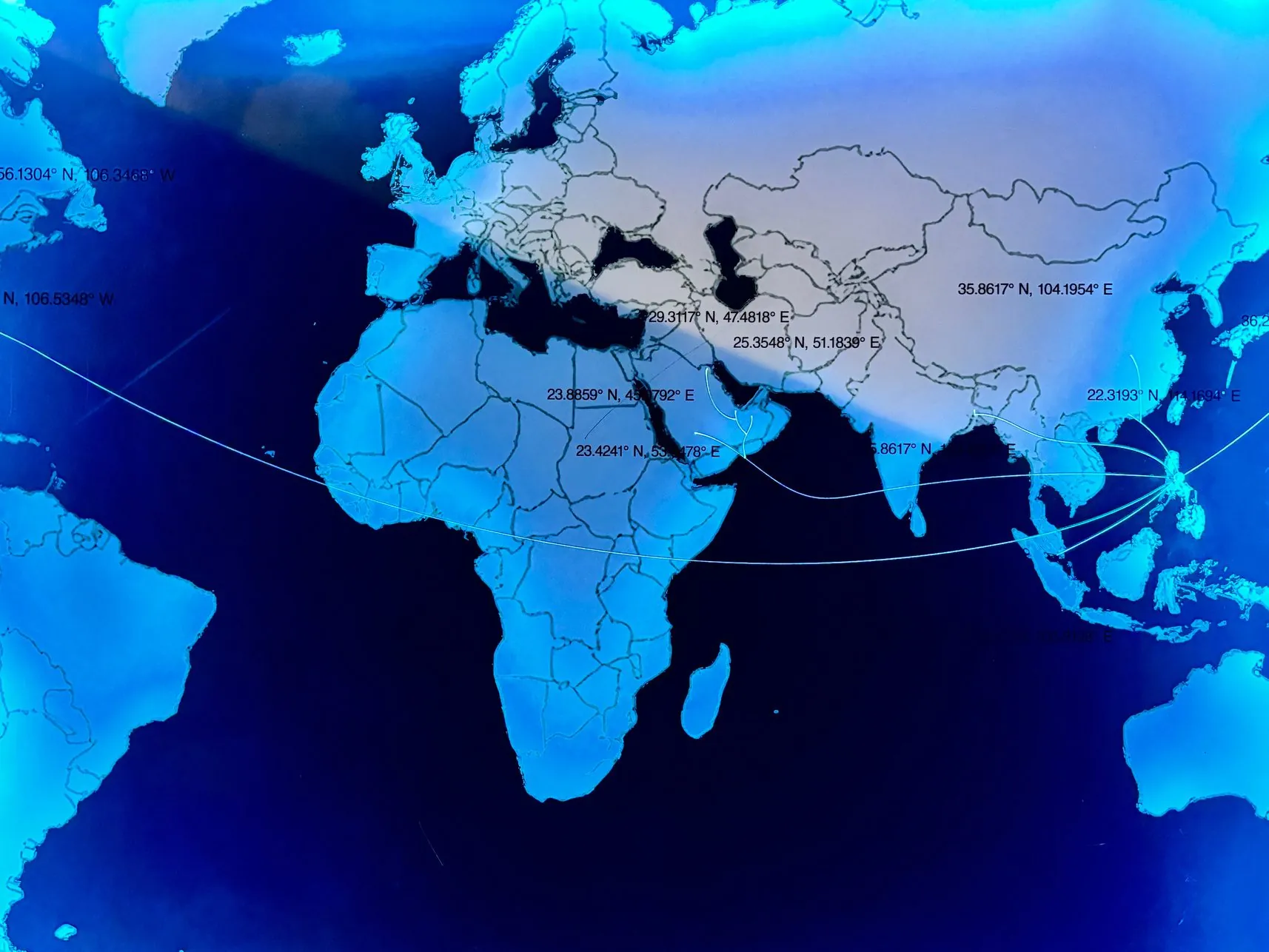Close-up of the map lit blue, with etched coordinates and routes from the Philippines